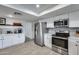 Updated kitchen area with stainless appliances, subway tile backsplash, and white cabinets with dark hardware at 19236 N 22Nd Ln, Phoenix, AZ 85027