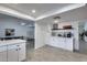 Open kitchen with a breakfast bar, white cabinetry, stainless appliances, and tile flooring at 19236 N 22Nd Ln, Phoenix, AZ 85027