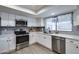 Well-lit kitchen showcasing stainless steel appliances, white cabinets and countertops, and gray subway tile backsplash at 19236 N 22Nd Ln, Phoenix, AZ 85027