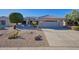 Charming single-story home featuring a two-car garage, desert landscaping, and a tile roof at 19460 N Hidden Canyon Dr, Surprise, AZ 85374