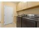 Bright laundry room with modern washer and dryer and storage cabinets at 19460 N Hidden Canyon Dr, Surprise, AZ 85374