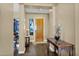 Elegant foyer with hardwood floors and a decorative table near the wooden front door at 2029 N 109Th Ave, Avondale, AZ 85392