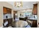 Kitchen featuring dark wood cabinets, stainless steel appliances, granite countertops, and dining table at 2029 N 109Th Ave, Avondale, AZ 85392