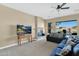 Inviting living room with fireplace, ceiling fan, and lake views from the large windows at 2029 N 109Th Ave, Avondale, AZ 85392