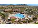 Aerial view of a community pool, clubhouse, and surrounding residential area nestled in desert landscape at 2046 N Red Clf, Mesa, AZ 85207