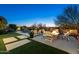 Inviting backyard with a fire pit, lounge chairs and sparkling pool at dusk at 2046 N Red Clf, Mesa, AZ 85207