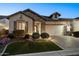 Charming home with a well-manicured front yard and a beautiful stone facade at dusk at 2046 N Red Clf, Mesa, AZ 85207