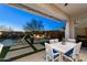 Inviting outdoor area featuring a covered patio with a dining area and a cozy fire pit space at 2046 N Red Clf, Mesa, AZ 85207