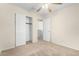 Bedroom with a ceiling fan, neutral carpeting, and a closet with sliding doors, maximizing space at 2406 W Tallgrass Trl, Phoenix, AZ 85085