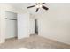 This bedroom features a ceiling fan, closet with doors, neutral colors, and carpet at 2406 W Tallgrass Trl, Phoenix, AZ 85085