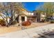 Delightful two-story home with red desert landscaping, a brown tiled roof, and brick paved driveway at 2406 W Tallgrass Trl, Phoenix, AZ 85085