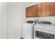 This laundry room features a washer, dryer, and wood cabinets at 2406 W Tallgrass Trl, Phoenix, AZ 85085