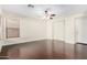 Spacious living room featuring hardwood floors, a ceiling fan with lights, and a window with blinds at 2406 W Tallgrass Trl, Phoenix, AZ 85085