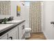 Modern bathroom with double vanity, white cabinets, black counters and walk-in shower at 2723 S 357Th Dr, Tonopah, AZ 85354