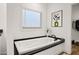 Relaxing bathroom features a soaking tub with black trim and modern fixtures, bright natural light at 2723 S 357Th Dr, Tonopah, AZ 85354