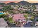 Scenic aerial view of a luxury home with a well-manicured backyard, set against a backdrop of mountains and desert landscape at 28826 N 67Th Dr, Peoria, AZ 85383