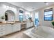 Bright bathroom featuring double vanities, soaking tub, and a door to a private balcony at 28826 N 67Th Dr, Peoria, AZ 85383