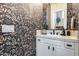 Charming powder room with a unique patterned wallpaper, white vanity, and elegant decor at 28826 N 67Th Dr, Peoria, AZ 85383