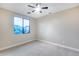 Bedroom features neutral paint, ceiling fan, light gray carpet, and window overlooking outdoors at 28826 N 67Th Dr, Peoria, AZ 85383