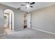 Bedroom showcases light gray carpet, ceiling fan and entrances to the hallway and bathroom at 28826 N 67Th Dr, Peoria, AZ 85383