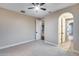 Bedroom boasts neutral paint, a ceiling fan, a light gray carpet and an arched entry at 28826 N 67Th Dr, Peoria, AZ 85383