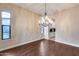 Hardwood dining room featuring a chandelier, natural light, and archway to the kitchen at 28826 N 67Th Dr, Peoria, AZ 85383