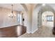 Elegant dining room with wood floors, an ornate chandelier, and views into the kitchen at 28826 N 67Th Dr, Peoria, AZ 85383