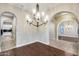 Dining room featuring wood floors, a chandelier, and an archway offering views of other rooms at 28826 N 67Th Dr, Peoria, AZ 85383