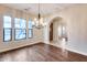 Dining area with hardwood flooring, chandelier lighting, and large windows overlooking the front yard at 28826 N 67Th Dr, Peoria, AZ 85383