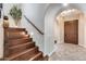 Elegant entryway features a dark wood front door, arched doorways, wood stairs, and decorative tiled flooring at 28826 N 67Th Dr, Peoria, AZ 85383