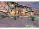 Elegant two-story home featuring stone accents, mature landscaping, and a tile roof under a beautiful sunset at 28826 N 67Th Dr, Peoria, AZ 85383