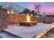 Inviting outdoor fire pit featuring a stone surround, perfect for cozy evenings with serene twilight sky in the background at 28826 N 67Th Dr, Peoria, AZ 85383