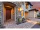 A close up of an elegant front door, stone accents, brick pavers, and lush desert landscaping at 28826 N 67Th Dr, Peoria, AZ 85383