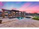 Inviting pool area with stone decking, pergola, and lush landscaping in a private backyard at 28826 N 67Th Dr, Peoria, AZ 85383