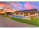 Inviting backyard showcasing a sparkling pool, patio seating, lush lawn, and sunset views at 297 W Chase St, San Tan Valley, AZ 85143