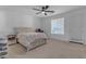 Bright bedroom features a bed with a white comforter, a nightstand, a ceiling fan, and a window at 297 W Chase St, San Tan Valley, AZ 85143