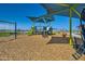 Bright community playground with swings, slides, and climbing structures on wood chip surface at 3205 E Outlaw Ln, San Tan Valley, AZ 85140