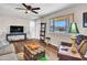 Charming living room featuring hardwood floors, a large window and stylish decorations at 3328 W Charter Oak Rd, Phoenix, AZ 85029