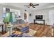 Cozy living room featuring wood flooring, a ceiling fan, comfortable seating and stylish decor at 3328 W Charter Oak Rd, Phoenix, AZ 85029