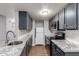 Galley kitchen features gray cabinets, stainless steel appliances, granite countertops, and white subway tile backsplash at 3416 N 44Th St # 70, Phoenix, AZ 85018