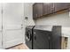 Functional laundry room with dark cabinets, washer and dryer, and access door at 3519 E Appaloosa Rd, Gilbert, AZ 85296