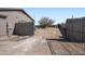 View of a fenced in backyard with a dirt yard and a large tree at 3545 N Hohokam Dr, Eloy, AZ 85131