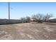 Wide shot of a fenced in backyard with a dirt yard and a large tree at 3545 N Hohokam Dr, Eloy, AZ 85131