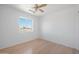 Bright bedroom features a ceiling fan, a large window, and light colored wood floors at 3545 N Hohokam Dr, Eloy, AZ 85131