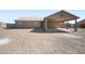 Wide shot of the front exterior elevation of the beige house featuring the carport at 3545 N Hohokam Dr, Eloy, AZ 85131