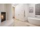 Bright bathroom featuring a modern soaking tub, fireplace, and tile flooring at 35530 N Canyon Crossings Dr, Carefree, AZ 85377