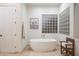 Bathroom featuring a soaking tub, travertine flooring and block glass at 35530 N Canyon Crossings Dr, Carefree, AZ 85377