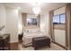 Stylish bedroom features a crystal chandelier, neutral tones, and a window view at 35530 N Canyon Crossings Dr, Carefree, AZ 85377