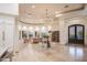 Bright living room with travertine floors, round tray ceiling, and iron door leading to the exterior of the home at 35530 N Canyon Crossings Dr, Carefree, AZ 85377