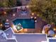 Aerial view of a backyard oasis featuring a pool, spa, outdoor seating, and lush desert landscaping at 35530 N Canyon Crossings Dr, Cave Creek, AZ 85331